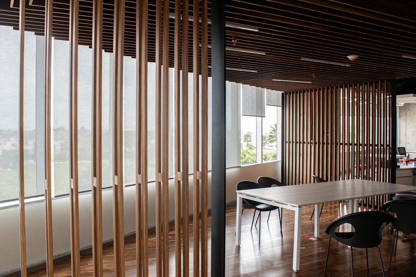Modern office meeting room with a long table and chairs.